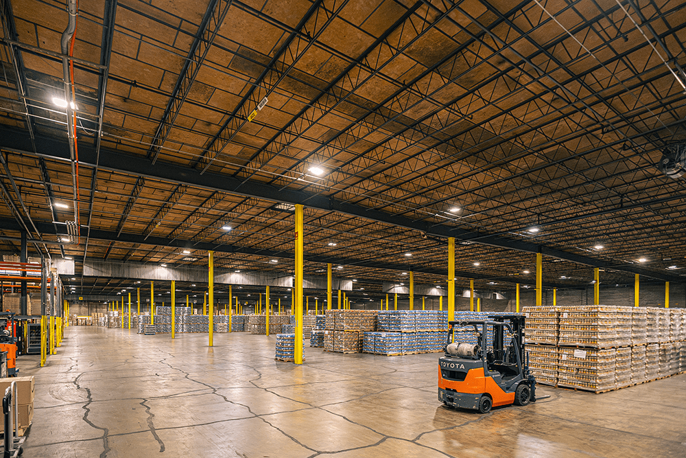 Wide-angle view of a vast warehouse interior with yellow support pillars.